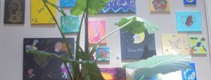 Photo d'une plante et d'un mur décoré de tableaux réalisé par les résidentes de la Maison d'accueil Jean Bru.